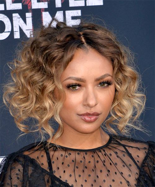 Kat Graham face framing curly bob parted in the center with large corkscrew curls