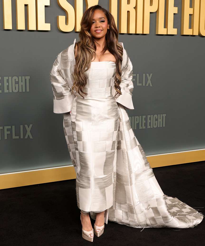 H.E.R. Hairstyle With Bold Curls And Blonde Highlights - view from the side